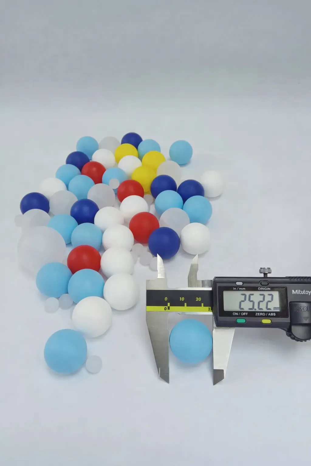 Grupo de bolillas plásticas de 25.22mm (0.993 pulgadas) con una siendo medida, mostrando ajuste preciso