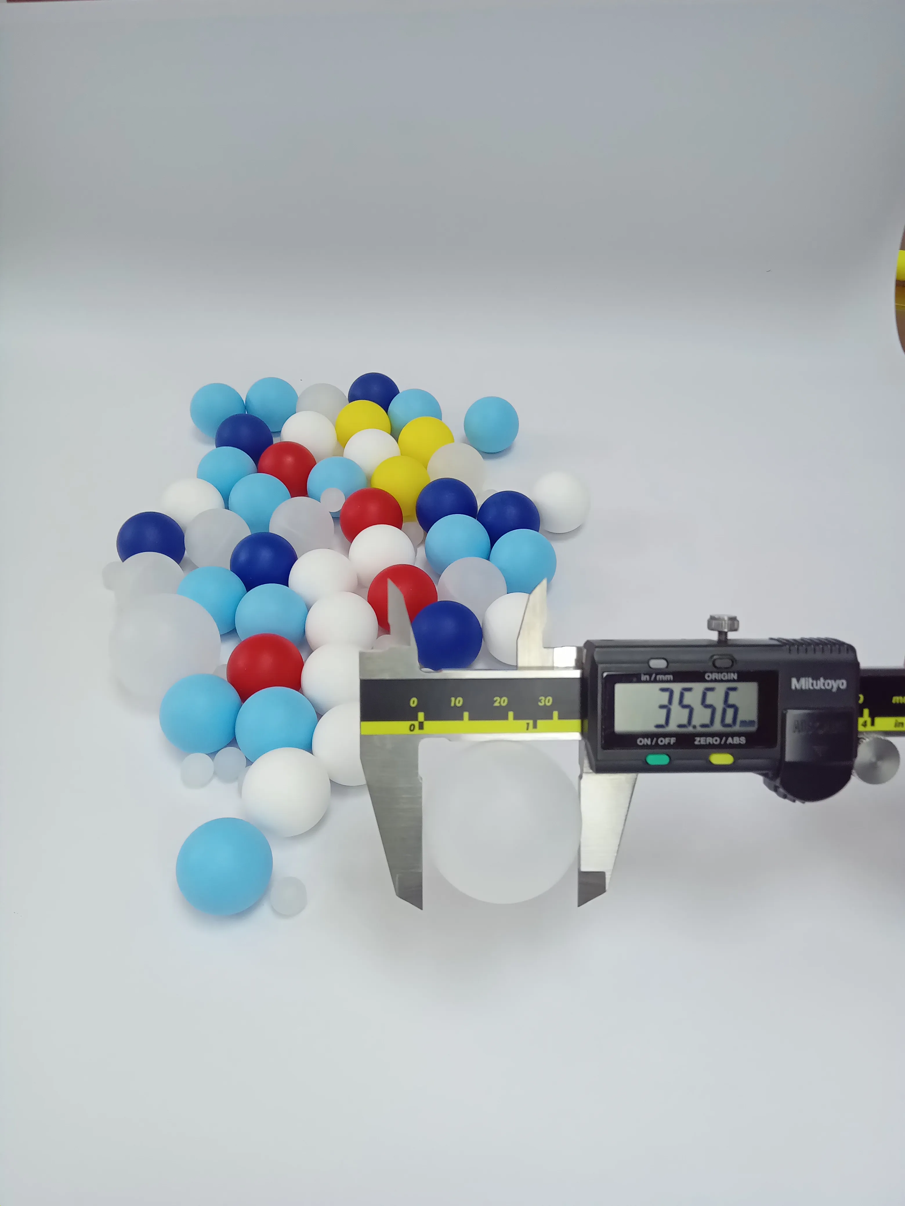 Bolilla plástica grande de 35.56mm (1.4 pulgadas) siendo medida con un calibrador digital para uso industrial